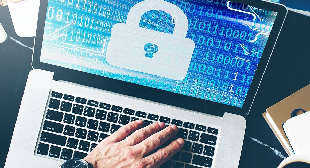 REISSWOLF Eine Hand auf einem Laptop