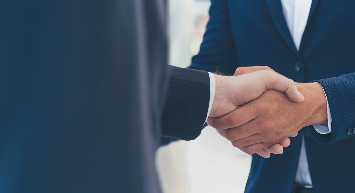 Zwei Männer im Anzug schütteln sich die Hand